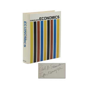 May include: A hardcover book titled "Economics" by Paul A. Samuelson. The book cover features a colorful striped design in black, yellow, red, blue, and brown. The book is signed by the author, Paul A. Samuelson, with the date "Tufts, February 1972".