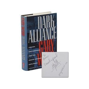 May include: A signed copy of the book "Dark Alliance: The CIA, the Contras, and the Crack Cocaine Explosion" by Gary Webb. The book cover features a dark blue background with the title in white and red text. The inscription reads "To Manno: Much regard, Gary Webb".