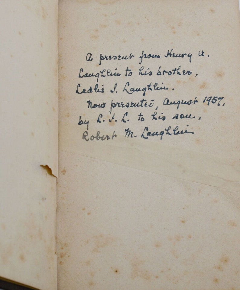 May include: A handwritten note on a page of a book. The note reads: "A present from Henry A. Laughlin to his brother, Ledlie J. Laughlin. Now presented, August 1957, by H.L. to his son, Robert M. Laughlin."