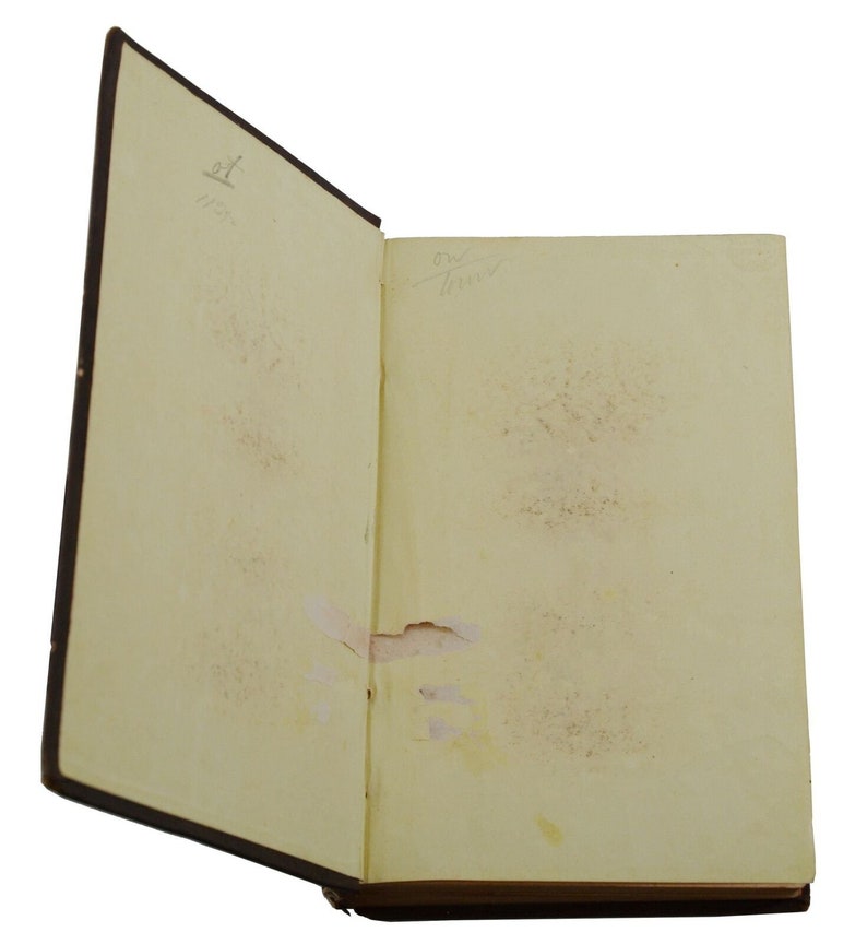 May include: An open book with a brown leather cover. The pages are yellowed with age and there are some small brown spots on the pages. The book is open to a blank page. There is some handwritten text on the inside cover of the book.
