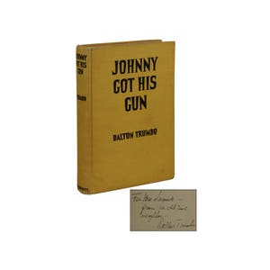 May include: A yellow book with the title "Johnny Got His Gun" by Dalton Trumbo. The book is signed by the author with the inscription "For Me Lammer - from the old-time negligee - Dalton Trumbo"
