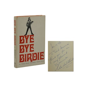 May include: A book titled "Bye Bye Birdie" by Michael Stewart, Lee Adams, and Charles Strouse. The cover features a cartoon illustration of a man in a sailor shirt holding a guitar. The book is signed by the author, "To Dick Maurice, Thank you for a very pleasant 26 minutes, Michael Stewart."
