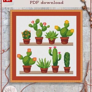 May include: Cross stitch pattern PDF download featuring a collection of potted cacti in various shapes and sizes. The cacti are green with pink and yellow flowers. The pattern is framed in a brown wooden frame.