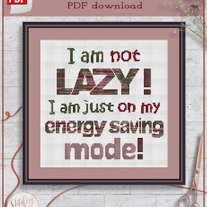 May include: Cross stitch pattern PDF download for a design that says "I am not LAZY! I am just on my energy saving mode!" The text is in red, green, and black with a pink background.