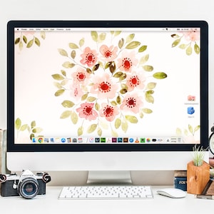 Può includere: Un computer desktop bianco con uno sfondo floreale con fiori rosa e verdi in acquerello. Il computer è su una scrivania bianca con una tastiera, un mouse e una fotocamera.