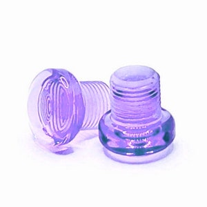 Puede incluir: Dos tapones de botella de plástico morado con un diseño roscado. Los tapones son translúcidos y tienen un ligero brillo.