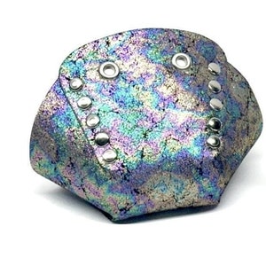 Puede incluir: Un par de punteras de zapatos de cuero azul y verde iridiscente con tachuelas plateadas.