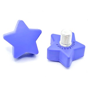 Puede incluir: Dos topes para patines de estrella de color morado. Un tope tiene el texto "Rollerstuff" impreso.