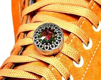 May include: Orange suede high-top sneakers with white laces and a silver charm with a multi-colored gemstone in the center.