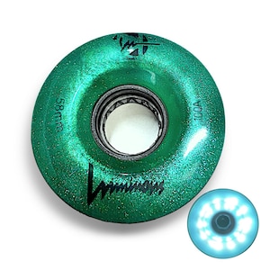 Puede incluir: Ruedas de monopatín verdes con acabado brillante. Las ruedas tienen un diámetro de 58 mm y una dureza de 100A. Las ruedas tienen un logotipo negro que dice "Luminary".