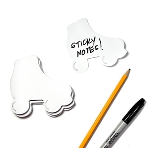 May include: White roller skate shaped sticky notes with the text "STICKY NOTES!" written on one of the notes. A yellow pencil and a black Sharpie marker are also in the image.