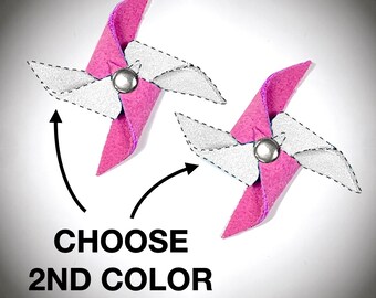 Puede incluir: Dos molinetes de fieltro rosa con aspas de fieltro blanco y centros de metal plateado. Los molinetes están sobre un fondo blanco con el texto "CHOOSE 2ND COLOR" debajo.