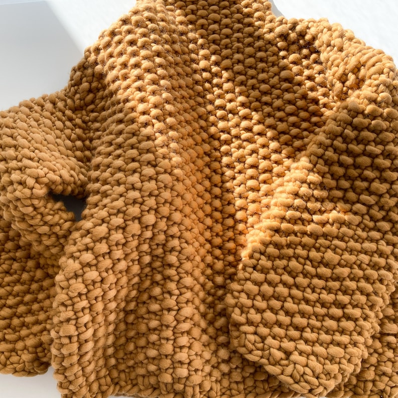 Beige chunky knit sweater close-up showing soft handmade merino wool texture.