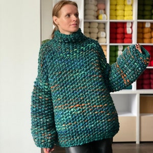 Green melange chunky knit sweater with oversized silhouette and wide sleeves, worn on a model.