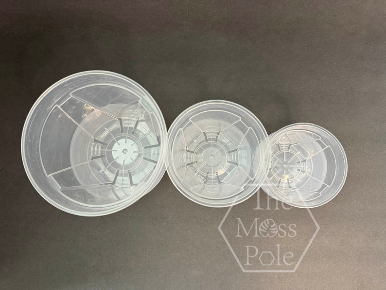 Peut inclure: Trois pots de fleurs en plastique transparent de diff&eacute;rentes tailles. Les pots ont un motif de grille au fond pour le drainage.