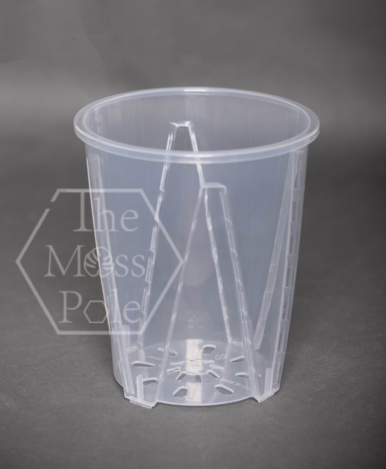 May include: A clear plastic plant pot with drainage holes and a ribbed design. The pot is designed to be used with a moss pole.