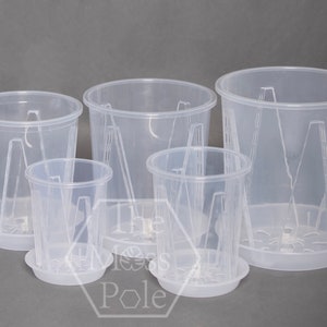 May include: Set of four clear plastic plant pots with drainage holes and matching saucers. The pots are different sizes and have a textured design.