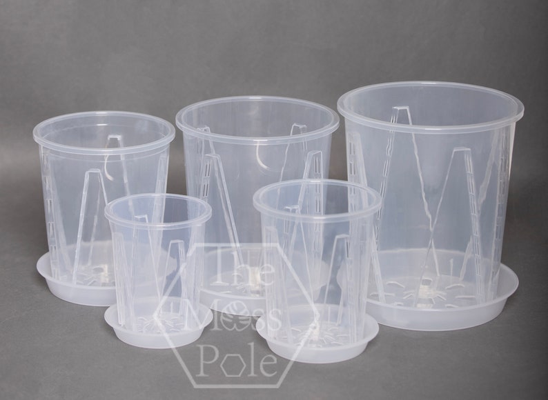 May include: Set of four clear plastic plant pots with drainage holes and matching saucers. The pots are different sizes and have a textured design.