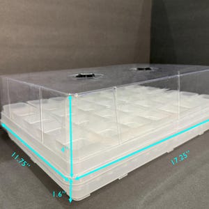 May include: A clear plastic propagation dome with a white base. The dome is 17.25 inches long, 11.75 inches wide, and 5.5 inches tall. The base is 1.6 inches tall.
