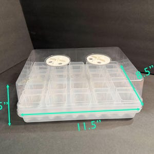 May include: Clear plastic seed starting tray with a clear lid. The tray is 11.5 inches long, 4.25 inches high, and 8.5 inches wide. It has 24 individual cells for starting seeds. Two white vents are on the lid.