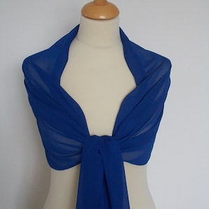 May include: Royal blue chiffon shawl draped over a mannequin. The shawl is tied in a knot at the front.