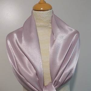 May include: A soft, mauve satin shawl draped over a mannequin. The shawl is tied in a knot at the front.