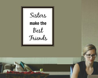 Puede incluir: Una cita enmarcada en una pared que dice "Sisters make the Best Friends". Una mujer está sentada en una mesa con un portátil, una taza de café y un plato con un pastel.