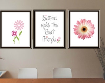 Puede incluir: Tres impresiones enmarcadas con un tema de flores rosas. La impresión de la izquierda presenta dos flores rosas con tallos verdes. La impresión del medio tiene el texto "Sisters make the best friends" con pequeñas flores rosas en la parte inferior. La impresión de la derecha presenta una sola flor rosa grande.