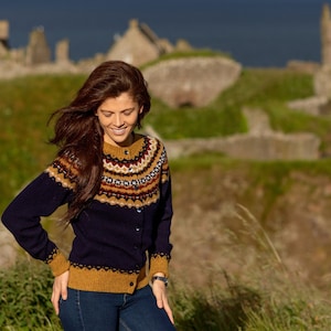 Model standing in front of ruined Scottish castle wearing Navy Crathie fairisle  cardigan