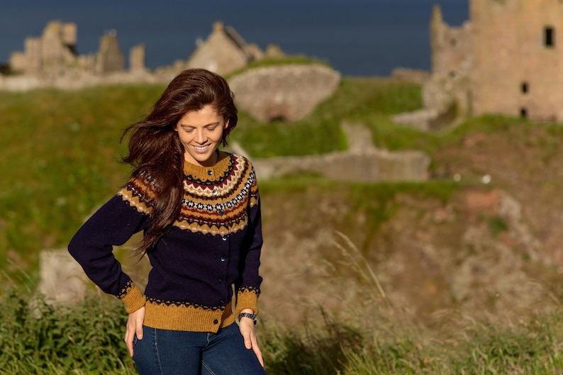 Model standing in front of ruined Scottish castle wearing Navy Crathie fairisle  cardigan