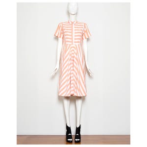 May include: A pink and white striped dress with a collared neckline and short sleeves. The dress has a fitted bodice and a flared skirt.