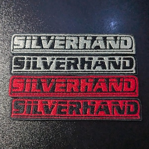 Puede incluir: Cuatro parches bordados con la palabra "SILVERHAND" en letras blancas y negras sobre un fondo rojo y negro.