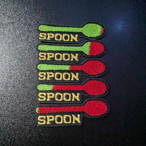 Puede incluir: Cinco parches bordados para planchar en forma de cuchara. Cada parche tiene la palabra "SPOON" en hilo amarillo y está dividido en dos, una mitad verde y la otra mitad roja.
