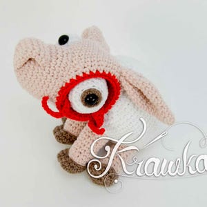 Pode incluir: Um brinquedo de porco de crochê feito à mão em tons de rosa, marrom e branco. O porco tem olhos grandes e pretos, um tapa-olho vermelho e uma capa branca. O brinquedo é projetado com uma estética lúdica e divertida.