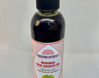 May include: A brown glass bottle with a black cap and a clear dropper. The bottle is labeled "Marabou Naturals" and "Moringa Hair Growth Oil". The label also says "Handmade with 100% Natural Ingredients" and "6oz / 177ml".