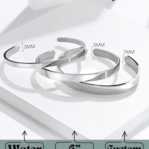 Pu&ograve; includere: Tre braccialetti rigidi argentati di diverse larghezze, 3 mm, 5 mm e 7 mm. I braccialetti sono lunghi 15 cm e regolabili. I braccialetti sono in acciaio inossidabile e sono impermeabili. I braccialetti possono essere incisi con un testo personalizzato all'interno, all'esterno o su entrambi i lati.