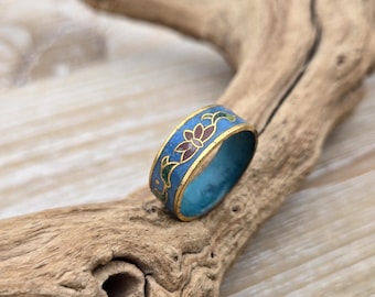 May include: A gold band ring with blue enamel and a floral design in red, green, and gold.