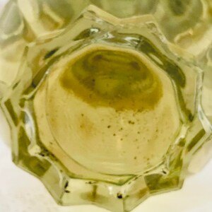 K&ouml;nnte beinhalten: Ein durchsichtiger Glasflaschenverschluss mit strukturierter Oberfl&auml;che. Der Verschluss hat eine hellbraune Farbe und ist mit einer klaren Fl&uuml;ssigkeit gef&uuml;llt.