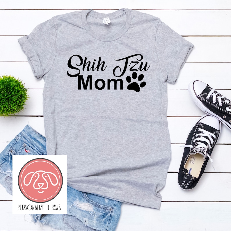 May include: Gray t-shirt with the text "Shih Tzu Mom" and a paw print in black.