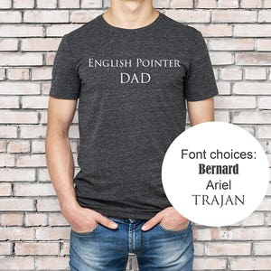 May include: A dark gray t-shirt with the text "ENGLISH POINTER DAD" printed on the front. Font choices: Bernard, Ariel, Trajan.