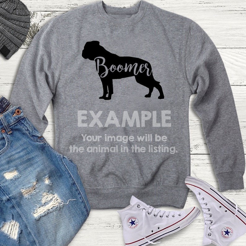 K&ouml;nnte beinhalten: Grauer Pullover mit einer schwarzen Silhouette eines Hundes und dem Wort "Boomer" in schwarzer Kursivschrift. Der Text "EXAMPLE" befindet sich unter dem Bild mit dem Text "Ihr Bild wird das Tier in der Liste sein."
