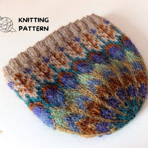 Pode incluir: Um chapéu de malha com um padrão geométrico colorido em tons de marrom, azul, verde e bege. O chapéu tem uma superfície texturizada e um ajuste ligeiramente folgado.