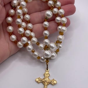 Rosario con crucifijo dorado, perlas blancas y cristales color champán. imagen 2