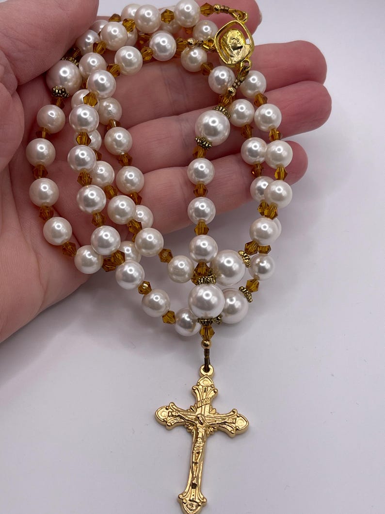 Rosario con crucifijo dorado, perlas blancas y cristales color champán. imagen 2