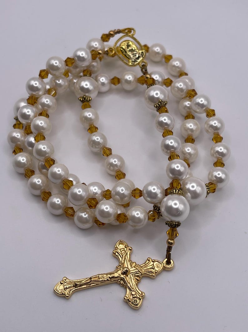 Rosario con crucifijo dorado, perlas blancas y cristales color champán. imagen 4