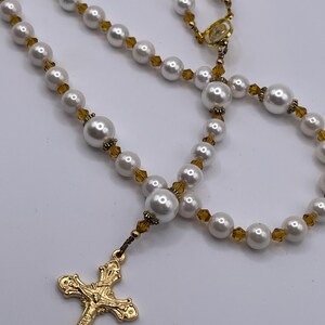 Rosario con crucifijo dorado, perlas blancas y cristales color champán. imagen 3