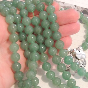 May include: A green jade beaded mala necklace with a silver charm that says "Healing".
