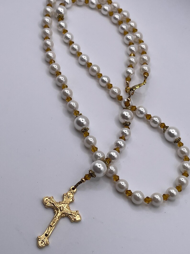 Rosario con crucifijo dorado, perlas blancas y cristales color champán. imagen 5