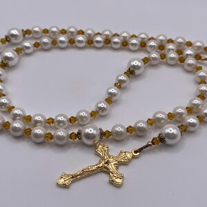 Rosario con crucifijo dorado, perlas blancas y cristales color champán. imagen 1