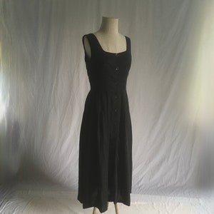 May include: A black sleeveless midi dress with a button-up front and a square neckline.